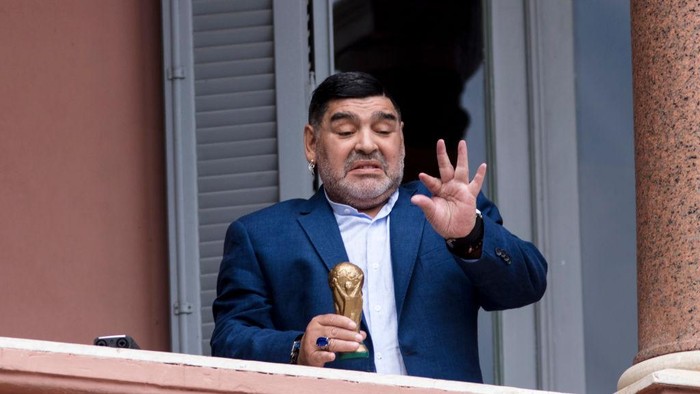 BUENOS AIRES, ARGENTINA - DECEMBER 26: Former Argentinian legend and current coach of Gimnasia y Esgrima La Plata Diego Maradona gestures with a small replica of the FIFA World Cup trophy at the balcony of Government house after a meeting with President of Argentina Alberto Fernandez at Casa Rosada on December 26, 2019 in Buenos Aires, Argentina. (Photo by Ricardo Ceppi/Getty Images)