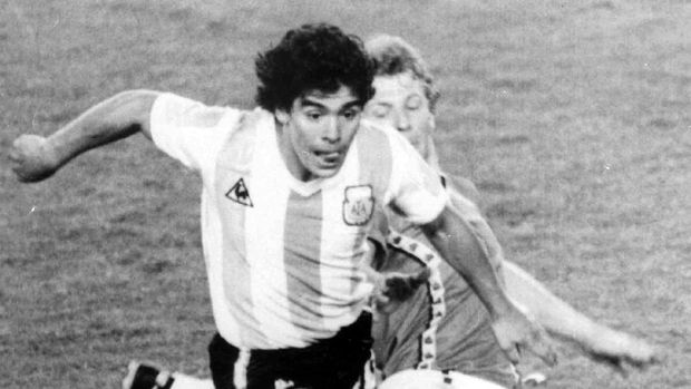 FILE - In this June 13, 1982 file photo, Argentina's Diego Maradona, front, is attacked by Belgium's Guy Vandermissen during the opening game of the Soccer World Cup in Barcelona, Spain. The Argentine soccer great who was among the best players ever and who led his country to the 1986 World Cup title before later struggling with cocaine use and obesity, died from a heart attack on Wednesday, Nov. 25, 2020, at home in Buenos Aires. He was 60. (AP Photo, File)