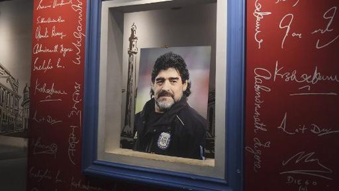 An employee prepares to place a picture of late Argentinian football legend Diego Armando Maradona at Mothers Wax Museum before the start of an event for Maradona fans to pay their respects, in Kolkata on November 26, 2020. - Maradona passed away on November 25, 2020. (Photo by Dibyangshu SARKAR / AFP)