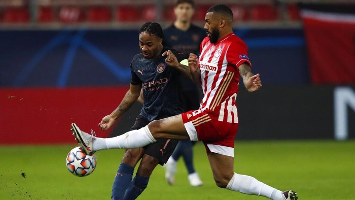 Manchester Citys Raheem Sterling , left, fights for the ball with Olympiacos Yann MVila During the Champions League, group C soccer match between Olympiacos and Manchester City at Georgios Karaiskakis stadium in Piraeus port, near Athens, Wednesday, Nov. 25, 2020. (AP Photo/Thanassis Stavrakis)