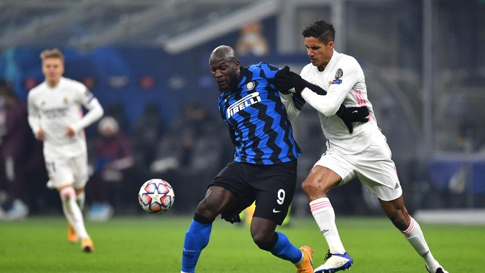MILAN, ITALY - NOVEMBER 25: Romelu Lukaku of Inter Milan is challenged by Raphael Varane of Real Madrid during the UEFA Champions League Group B stage match between FC Internazionale and Real Madrid at Stadio Giuseppe Meazza on November 25, 2020 in Milan, Italy. Football Stadiums around Europe remain empty due to the Coronavirus Pandemic as Government social distancing laws prohibit fans inside venues resulting in fixtures being played behind closed doors. (Photo by Valerio Pennicino/Getty Images)