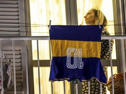 Seorang warga Naples memajang baju Boca Juniors yang identik dengan Maradona di balkon rumahnya. Maradona meninggal dunia akibat henti jantung di rumahnya, Rabu (25/11/2020) malam WIB. Alessandro Garofalo/LaPresse via AP.