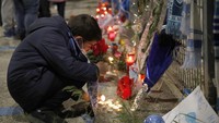 Seorang anak menyalakan lilin di luar Stadion San Paolo. Diego Maradona meninggal di usia 60 tahun. AP Photo/Alessandra Tarantino.