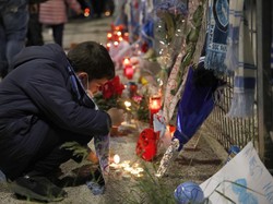 Seorang anak menyalakan lilin di luar Stadion San Paolo. Diego Maradona meninggal di usia 60 tahun. AP Photo/Alessandra Tarantino.