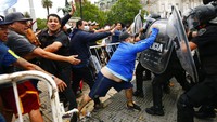 Sejumlah petugas kepolisian tampak berjaga di area istana kepresidenan Argentina menyusul banyaknya warga yang datang ke sana untuk memberikan penghormatan terakhir bagi Maradona. AP Photo/Marcos Brindicci.