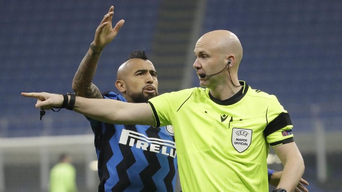 Inter Milans Arturo Vidal, left, argues with referee Anthony Taylor during the Group B, Champions League soccer match between Inter Milan and Real Madrid at the San Siro Stadium, in Milan, Italy, Wednesday, Nov. 25, 2020. (AP Photo/Luca Bruno)
