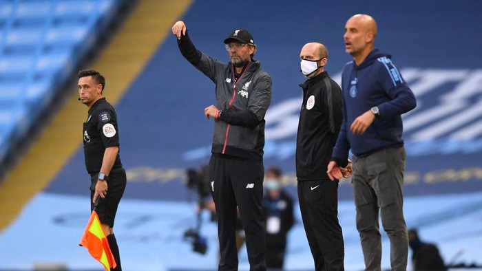 MANCHESTER, ENGLAND - JULY 02: Jurgen Klopp, Manager of Liverpool gives his team instructions as Pep Guardiola, Manager of Manchester City looks on during the Premier League match between Manchester City and Liverpool FC at Etihad Stadium on July 02, 2020 in Manchester, England. Football Stadiums around Europe remain empty due to the Coronavirus Pandemic as Government social distancing laws prohibit fans inside venues resulting in all fixtures being played behind closed doors. (Photo by Laurence Griffiths/Getty Images)