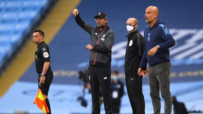 Juergen Klopp-Pep Guardiola MANCHESTER, ENGLAND - JULY 02: Jurgen Klopp, Manager of Liverpool gives his team instructions as Pep Guardiola, Manager of Manchester City looks on during the Premier League match between Manchester City and Liverpool FC at Etihad Stadium on July 02, 2020 in Manchester, England. Football Stadiums around Europe remain empty due to the Coronavirus Pandemic as Government social distancing laws prohibit fans inside venues resulting in all fixtures being played behind closed doors. (Photo by Laurence Griffiths/Getty Images)