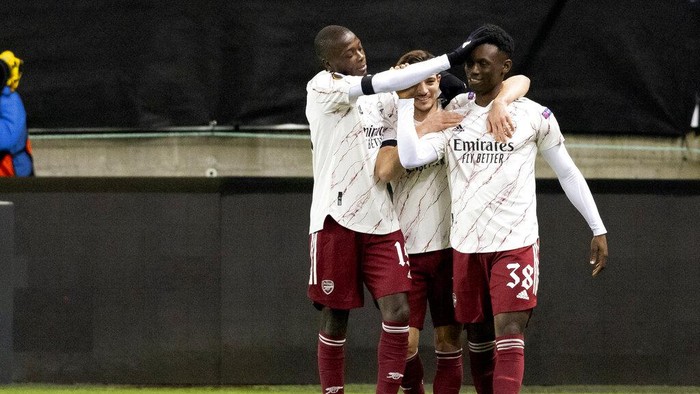 Arsenals Folarin Balogun, right, is congratulated for scoring to take the score to 0-3, by Cedric and Nicolas Pepe, left, during the Europa League Group stage Group B, soccer match between Molde and Arsenal at Aker Stadium in Molde, Norway, Thursday Nov. 26, 2020. (Svein Ove Ekornesvag / NTB via AP)