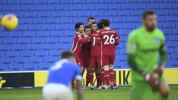 Liverpool's Diogo Jota, center, is hugged by teammates after scoring during the English Premier League soccer match between Brighton and Hove Albion and Liverpool at the Amex stadium in Brighton, England, Saturday, Nov. 28, 2020. (Mike Hewitt/Pool Via AP)