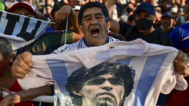 Fans gather outside the morgue where the late Argentine football star Diego Maradona's body will undergo an autopsy 