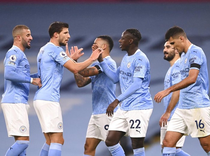 Manchester Citys Benjamin Mendy celebrates with teammates after scoring his sides third goal during the English Premier League soccer match between Manchester City and Burnley at the Etihad stadium in Manchester, England, Saturday, Nov. 28, 2020. (Laurence Griffiths/Pool via AP)