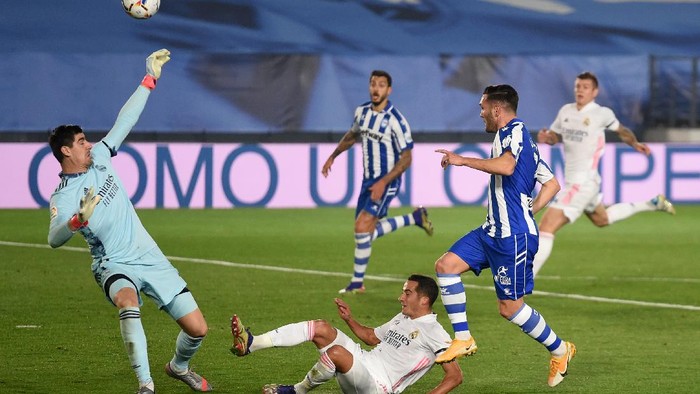 MADRID, SPAIN - NOVEMBER 28: Thibaut Courtois of Real Madrid saves a shot from Lucas of Deportivo Alaves during the La Liga Santander match between Real Madrid and Deportivo Alaves at Estadio Santiago Bernabeu on November 28, 2020 in Madrid, Spain. Football Stadiums around Europe remain empty due to the Coronavirus Pandemic as Government social distancing laws prohibit fans inside venues resulting in fixtures being played behind closed doors. (Photo by Denis Doyle/Getty Images)