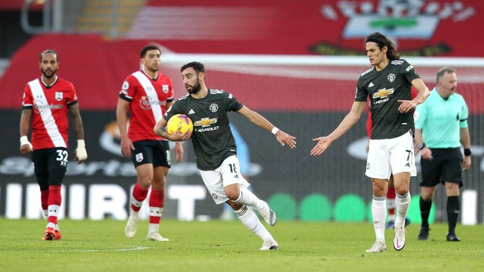 SOUTHAMPTON, ENGLAND - NOVEMBER 29: Bruno Fernandes of Manchester United runs back with the ball and is congratulated by team mate Edinson Cavani after scoring their sides first goal during the Premier League match between Southampton and Manchester United at St Marys Stadium on November 29, 2020 in Southampton, England. Sporting stadiums around the UK remain under strict restrictions due to the Coronavirus Pandemic as Government social distancing laws prohibit fans inside venues resulting in games being played behind closed doors. (Photo by Naomi Baker/Getty Images)