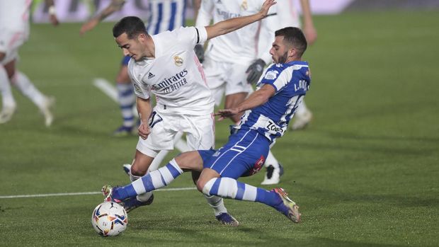 Real Madrid's Lucas Vazquez, left, is fouled by Alaves' Luis Rioja during the Spanish La Liga soccer match between Real Madrid and Alaves at Alfredo di Stefano stadium in Madrid, Spain, Saturday, Nov. 28, 2020. (AP Photo/Bernat Armangue)