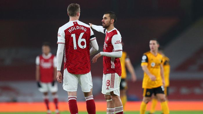 Arsenal LONDON, ENGLAND - NOVEMBER 29: Dani Ceballos of Arsenal talks to Rob Holding of Arsenal during the Premier League match between Arsenal and Wolverhampton Wanderers at Emirates Stadium on November 29, 2020 in London, England. Sporting stadiums around the UK remain under strict restrictions due to the Coronavirus Pandemic as Government social distancing laws prohibit fans inside venues resulting in games being played behind closed doors. (Photo by Catherine Ivill/Getty Images)