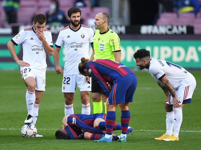 BARCELONA, SPAIN - NOVEMBER 29: Clement Lenglet of Barcelona lies injured and is checked on by Antoine Griezmann of Barcelona during the La Liga Santander match between FC Barcelona and C.A. Osasuna at Camp Nou on November 29, 2020 in Barcelona, Spain. Sporting stadiums around Spain remain under strict restrictions due to the Coronavirus Pandemic as Government social distancing laws prohibit fans inside venues resulting in games being played behind closed doors. (Photo by David Ramos/Getty Images)