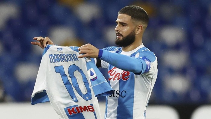 Lorenzo Insigne of Napoli holding a number 10 Maradona shirt, celebrates after scoring the first goal of the game against AS Roma, during their Serie A soccer match between Napoli and Roma, at the Naples San Paolo Stadium in Naples, Italy, Sunday, Nov. 29, 2020. (Alessandro Garofalo/LaPresse via AP)