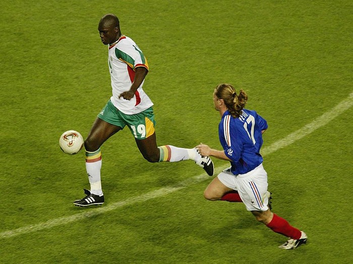 SEOUL - MAY 31:  Papa Bouba Diop (left) of Senegal is chased by Emmanuel Petit (right) of France during the France v Senegal Group A, World Cup Group  Stage match played at the Seoul World Cup Stadium, Seoul, South Korea on May 31, 2002. Senegal won the match 1-0. (Photo by Brian Bahr/Getty Images)