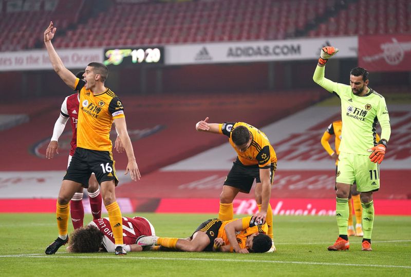 LONDON, ENGLAND - NOVEMBER 29: David Luiz of Arsenal and Raul Jimenez of Wolverhampton Wanderers lie injured after a collision during the Premier League match between Arsenal and Wolverhampton Wanderers at Emirates Stadium on November 29, 2020 in London, England. Sporting stadiums around the UK remain under strict restrictions due to the Coronavirus Pandemic as Government social distancing laws prohibit fans inside venues resulting in games being played behind closed doors. (Photo by John Walton - Pool/Getty Images)