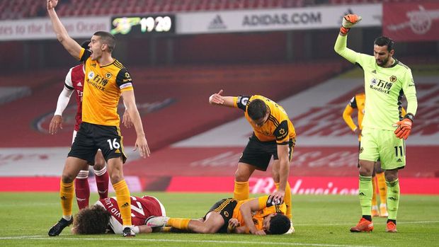 LONDON, ENGLAND - NOVEMBER 29: David Luiz of Arsenal and Raul Jimenez of Wolverhampton Wanderers lie injured after a collision during the Premier League match between Arsenal and Wolverhampton Wanderers at Emirates Stadium on November 29, 2020 in London, England .  Sports stadiums across the UK remain under strict restrictions due to the coronavirus pandemic, as government social distancing laws prohibit fans within venues, causing games to be played behind closed doors.  (Photo by John Walton - Pool / Getty Images)