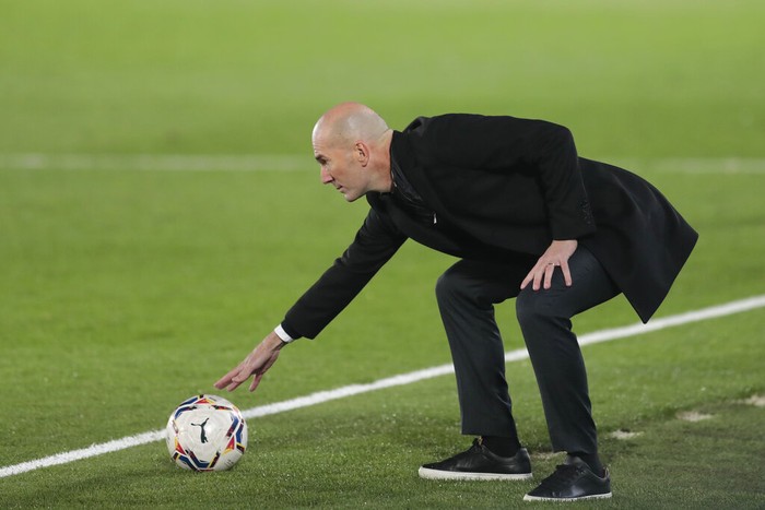 Real Madrids head coach Zinedine Zidane touches a ball during the Spanish La Liga soccer match between Real Madrid and Alaves at Alfredo di Stefano stadium in Madrid, Spain, Saturday, Nov. 28, 2020. (AP Photo/Bernat Armangue)