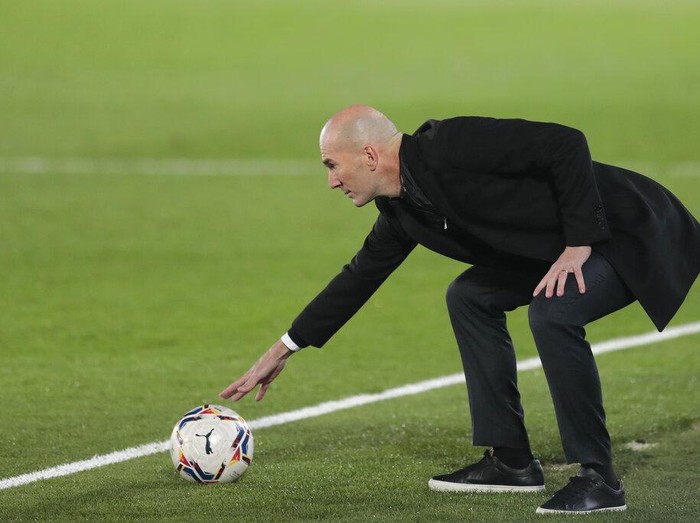Real Madrid's head coach Zinedine Zidane touches a ball during the Spanish La Liga soccer match between Real Madrid and Alaves at Alfredo di Stefano stadium in Madrid, Spain, Saturday, Nov. 28, 2020. (AP Photo/Bernat Armangue)