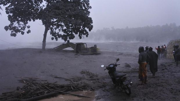 Warga melihat banjir lahar dingin Gunung Semeru di kawasan Besuk Kobokan, Pronojiwo, Lumajang, Jawa Timur, Selasa (1/12/2020). Banjir lahar dingin mengakibatkan terputusnya akses jalan antar kecamatan di Lumajang serta sejumlah truk dan alat berat penambang pasir terjebak. ANTARA FOTO/Seno/rwa.