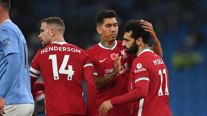 MANCHESTER, ENGLAND - NOVEMBER 08: Mohamed Salah of Liverpool celebrates with teammates Roberto Firmino and Jordan Henderson after scoring his teams first goal during the Premier League match between Manchester City and Liverpool at Etihad Stadium on November 08, 2020 in Manchester, England. Sporting stadiums around the UK remain under strict restrictions due to the Coronavirus Pandemic as Government social distancing laws prohibit fans inside venues resulting in games being played behind closed doors. (Photo by Shaun Botterill/Getty Images)
