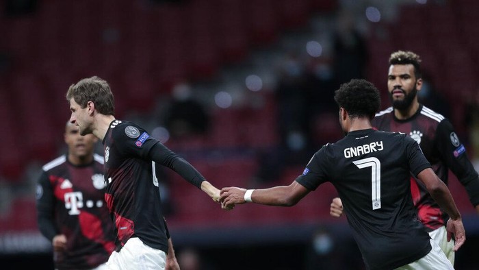 Bayerns Thomas Mueller, left, celebrates after scoring a penalty kick during the Champions League group A soccer match between Atletico Madrid and Bayern Munich at the Wanda Metropolitano stadium in Madrid, Spain, Tuesday, Dec. 1, 2020. (AP Photo/Bernat Armangue)