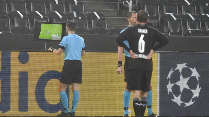 Referee Danny Makkelie checks the VAR monitor during the Champions League, Group B, soccer match between Borussia Moenchengladbach and Inter Milan at the Borussia Park in Moenchengladbach, Germany, Tuesday, Dec. 1, 2020. (AP Photo/Martin Meissner)