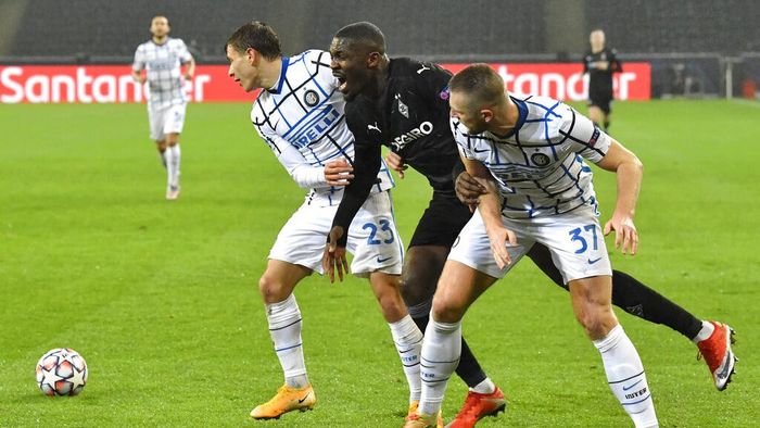 Germany Soccer Champions League Moenchengladbachs Marcus Thuram, center, is challenged by Inter Milans Nicolo Barella, left, and Inter Milans Milan Skriniar during the Champions League, Group B, soccer match between Borussia Moenchengladbach and Inter Milan at the Borussia Park in Moenchengladbach, Germany, Tuesday, Dec. 1, 2020. (AP Photo/Martin Meissner)
