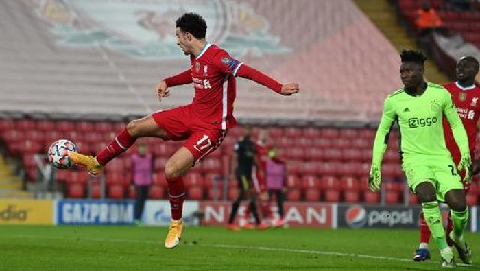Liverpool Liverpools English midfielder Curtis Jones (L) scores the opening goal after a mistake from Ajaxs Cameroon goalkeeper Andre Onana (R) during the UEFA Champions League 1st round Group D football match between Liverpool and Ajax at Anfield in Liverpool, north west England on December 1, 2020. (Photo by Paul ELLIS / POOL / AFP)