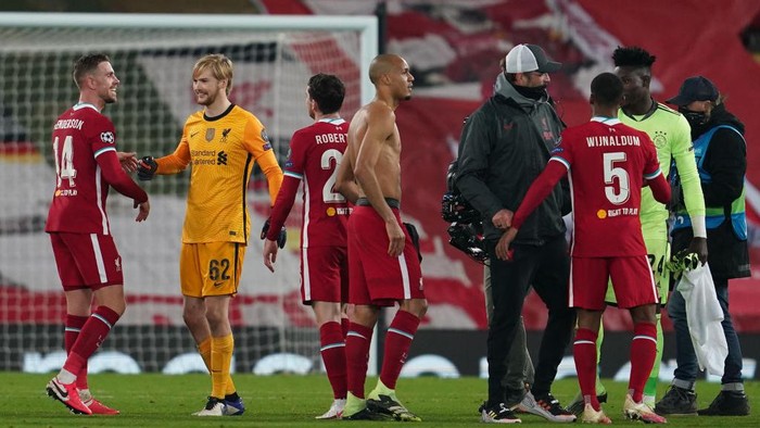 LIVERPOOL, ENGLAND - DECEMBER 01: Jordan Henderson of Liverpool and Caoimhin Kelleher of Liverpool celebrate following their teams victory, as Jurgen Klopp, Manager of Liverpool speaks with Andre Onana of Ajax and Georginio Wijnaldum of Liverpool following the UEFA Champions League Group D stage match between Liverpool FC and Ajax Amsterdam at Anfield on December 01, 2020 in Liverpool, England. Sporting stadiums around the UK remain under strict restrictions due to the Coronavirus Pandemic as Government social distancing laws prohibit fans inside venues resulting in games being played behind closed doors. (Photo by Jon Super - Pool/Getty Images)