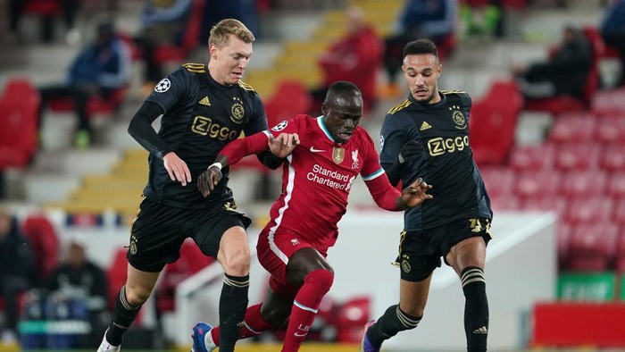 LIVERPOOL, ENGLAND - DECEMBER 01: Sadio Mane of Liverpool is challenged by Perr Schuurs and Jurgen Ekkelenkamp of Ajax during the UEFA Champions League Group D stage match between Liverpool FC and Ajax Amsterdam at Anfield on December 01, 2020 in Liverpool, England. Sporting stadiums around the UK remain under strict restrictions due to the Coronavirus Pandemic as Government social distancing laws prohibit fans inside venues resulting in games being played behind closed doors. (Photo by Jon Super - Pool/Getty Images)