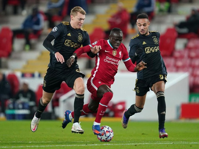 LIVERPOOL, ENGLAND - DECEMBER 01: Sadio Mane of Liverpool is challenged by Perr Schuurs and Jurgen Ekkelenkamp of Ajax during the UEFA Champions League Group D stage match between Liverpool FC and Ajax Amsterdam at Anfield on December 01, 2020 in Liverpool, England. Sporting stadiums around the UK remain under strict restrictions due to the Coronavirus Pandemic as Government social distancing laws prohibit fans inside venues resulting in games being played behind closed doors. (Photo by Jon Super - Pool/Getty Images)