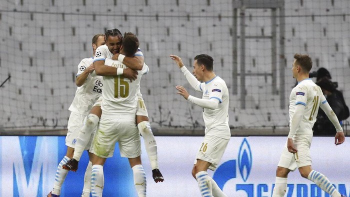 Marseilles Dimitri Payet , second left, celebrates with his teammates , after scoring the second goal of his team against Olympiacos during the Champions League group C soccer match between Olympique Marseille and Olympiacos at the Velodrome stadium in Marseille, southern France, Tuesday, Dec. 1, 2020. (AP Photo/Daniel Cole)