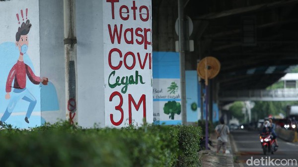 eorang seniman melukis mural di kolong Tol Wiyoto Wiyono, Jakarta Timur, Rabu (2/12/2020). Nantinya akan ada 100 tiang TOL yang akan dimural dengan gambar protokol kesehatan.