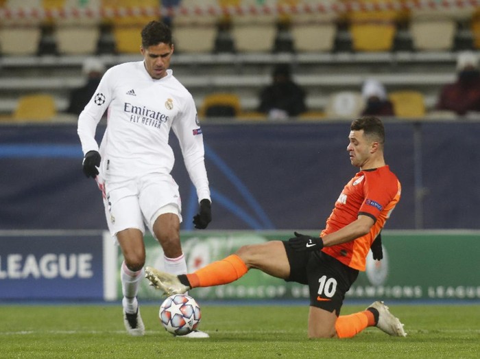 Real Madrids Raphael Varane, left, and Shakhtars Junior Moraes challenge for the ball during the Champions League, Group B, soccer match between Shakhtar Donetsk and Real Madrid at the Olimpiyskiy Stadium in Kyiv, Ukraine, Tuesday, Dec. 1, 2020. (AP Photo/Efrem Lukatsky)