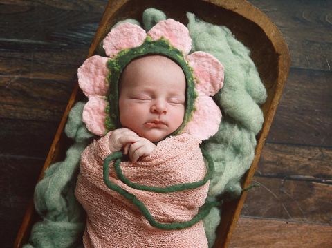 The baby was excited and delighted in the pink cloth.