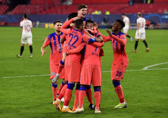 SEVILLE, SPAIN - DECEMBER 02: Olivier Giroud of Chelsea (obscured) celebrates with teammates after scoring their teams third goal, their hat-trick during the UEFA Champions League Group E stage match between FC Sevilla and Chelsea FC at Estadio Ramon Sanchez Pizjuan on December 02, 2020 in Seville, Spain. Sporting stadiums around Spain remain under strict restrictions due to the Coronavirus Pandemic as Government social distancing laws prohibit fans inside venues resulting in games being played behind closed doors. (Photo by David Ramos/Getty Images)
