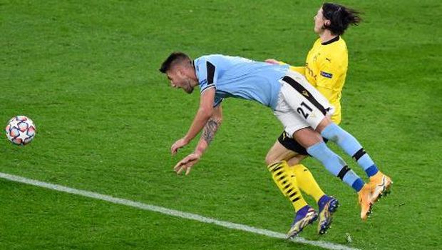 Dortmund's German defender Nico Schulz (R) fouls Lazio's Serbian midfielder Sergej Milinkovic-Savic giving away a penalty during the UEFA Champions League group F football match BVB Borussia Dortmund v Lazio in Dortmund, western Germany, on December 2, 2020. (Photo by Bernd Thissen / POOL / AFP)