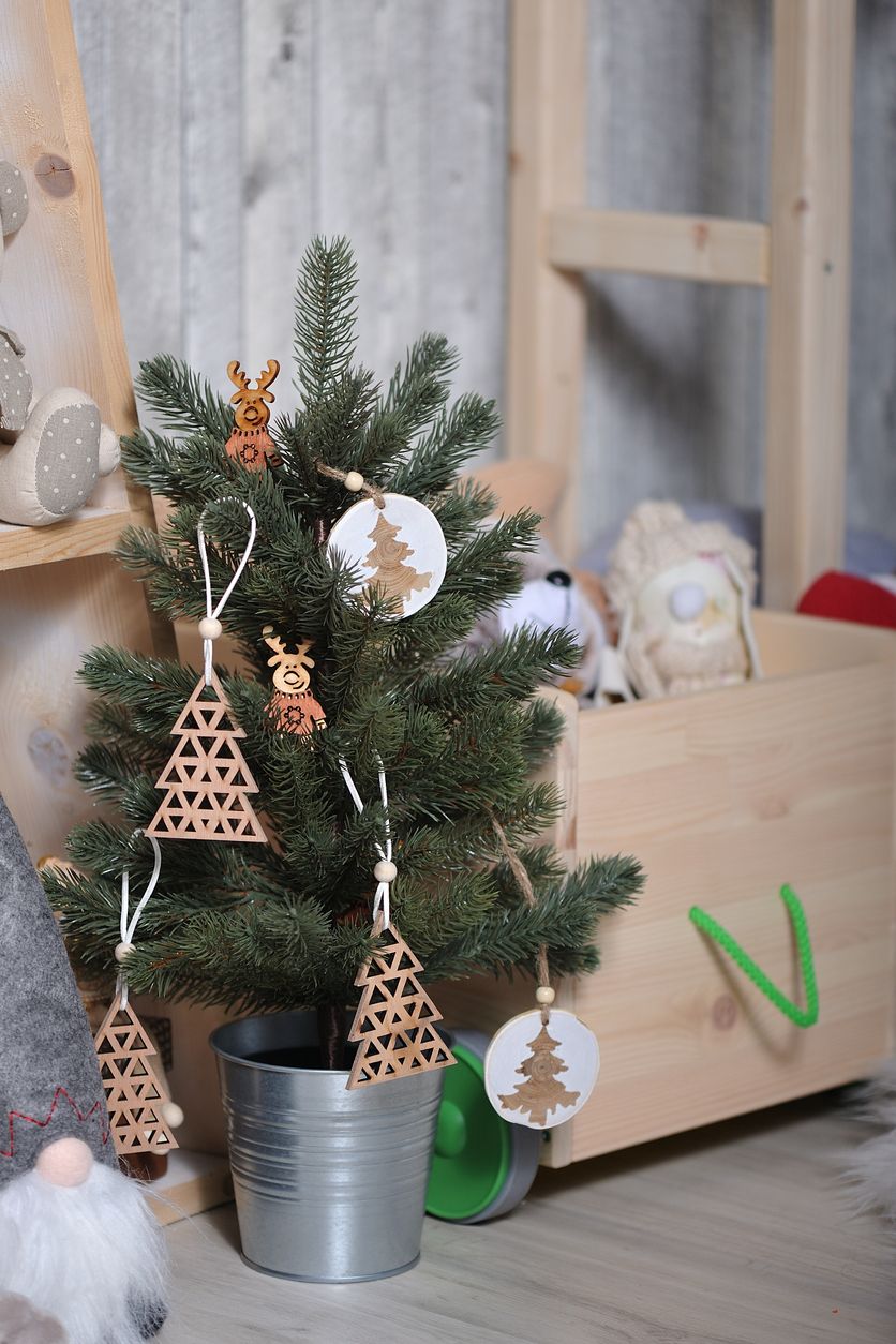 Small Christmas tree in a bucket with children's toys background