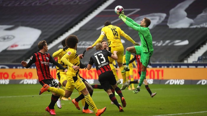 FRANKFURT AM MAIN, GERMANY - DECEMBER 05: Kevin Trapp of Eintracht Frankfurt punches the ball clear from Mats Hummels of Borussia Dortmund  during the Bundesliga match between Eintracht Frankfurt and Borussia Dortmund at Deutsche Bank Park on December 05, 2020 in Frankfurt am Main, Germany. Football Stadiums around Germany remain empty due to the Coronavirus Pandemic as Government social distancing laws prohibit fans inside venues resulting in fixtures being played behind closed doors. (Photo by Alex Grimm/Getty Images)