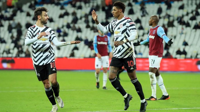 LONDON, ENGLAND - DECEMBER 05: Marcus Rashford of Manchester United celebrates with teammate Bruno Fernandes  after scoring his teams third goal during the Premier League match between West Ham United and Manchester United at London Stadium on December 05, 2020 in London, England. A limited number of fans are welcomed back to stadiums to watch elite football across England. This was following easing of restrictions on spectators in tiers one and two areas only. (Photo by Adam Davy - Pool/Getty Images)