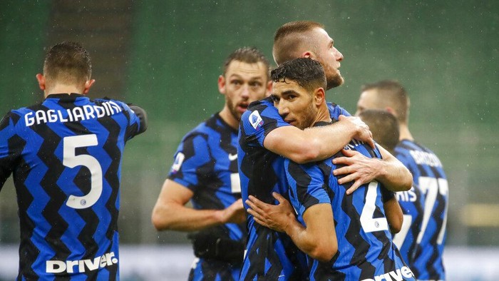 Inter Milans Achraf Hakimi, right, celebrates with his teammates after he scored his sides second goal during a Serie A soccer match between Inter Milan and Bologna, at Milans San Siro Stadium, Saturday, Dec. 5, 2020. (AP Photo/Antonio Calanni)