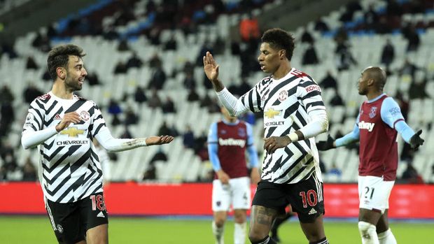 Manchester United's Marcus Rashford, right, celebrates with teammate Manchester United's Bruno Fernandes after scoring his side's third goal during the English Premier League soccer match between West Ham United and Manchester United at the London stadium in London, England, Saturday, Dec. 5, 2020.(Adam Davy / Pool via AP)