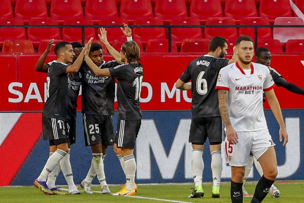 Real Madrid's players celebrate a goal during the Spanish La Liga soccer match between Sevilla and Real Madrid at the Ramon Sanchez Pizjuan stadium in Seville, Spain, Saturday Dec. 5, 2020. (AP Photo/Angel Fernandez)