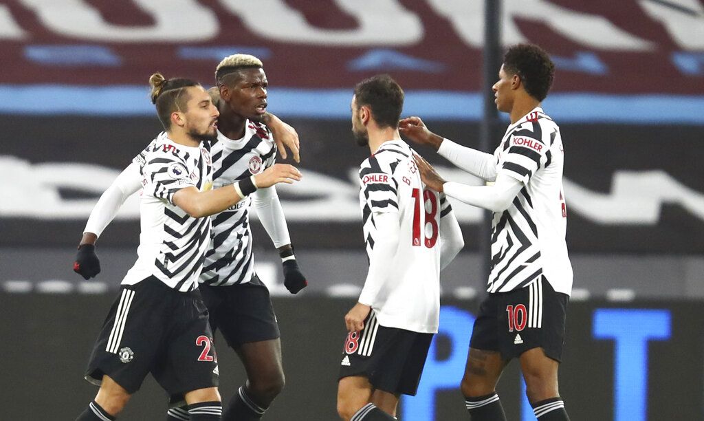 Manchester United's Paul Pogba, second left, celebrates with teammates after scoring his side's opening goal during the English Premier League soccer match between West Ham United and Manchester United at the London stadium in London, England, Saturday, Dec. 5, 2020. (Julian Finney/Pool Via AP)
