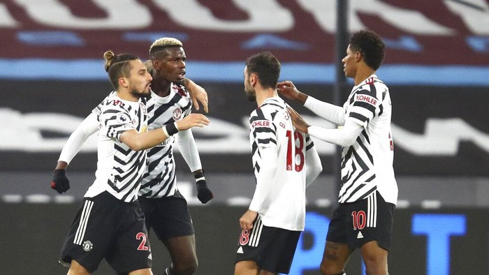 Manchester Uniteds Paul Pogba, second left, celebrates with teammates after scoring his sides opening goal during the English Premier League soccer match between West Ham United and Manchester United at the London stadium in London, England, Saturday, Dec. 5, 2020. (Julian Finney/Pool Via AP)